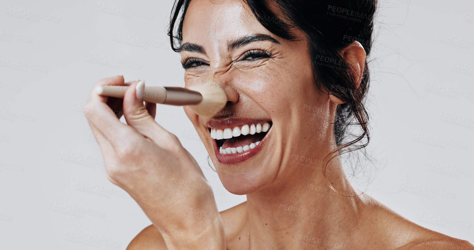 Buy stock photo Woman, makeup brush and laugh in studio portrait for beauty, powder and application on white background. Mature person, cosmetics and tools for foundation on nose, playful and smile in New Zealand
