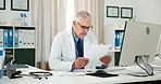 Documents, doctor and reading with man in office  of hospital for report, medical diagnosis or research. Healthcare expert, paperwork or treatment update with mature person in clinic for feedback