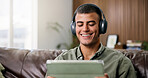 Laugh, tablet and man on sofa with headphones for online videos, subscription and watching movies. Home, happy and person on digital tech for internet, website and streaming to relax on weekend