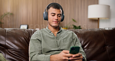 Buy stock photo Man, phone and relax with headphones on sofa for streaming, smile and sound in living room at house. Person, smartphone and listen to music with subscription, mobile app or audio on couch in home