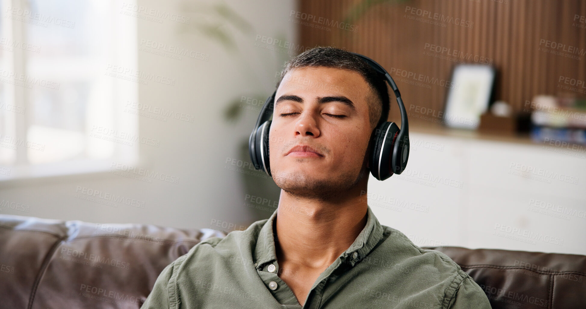 Buy stock photo Man, headphones and relax on sofa with streaming, chill audio and break on weekend in home. Male person, music and listening to song with eyes closed, reflection or podcast in house living room