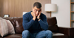 Man, sad and thinking on sofa in home for reflection, stress or mental health in living room. Person with depression, frustrated or ptsd in lounge with regret, anxiety or remember trauma at apartment
