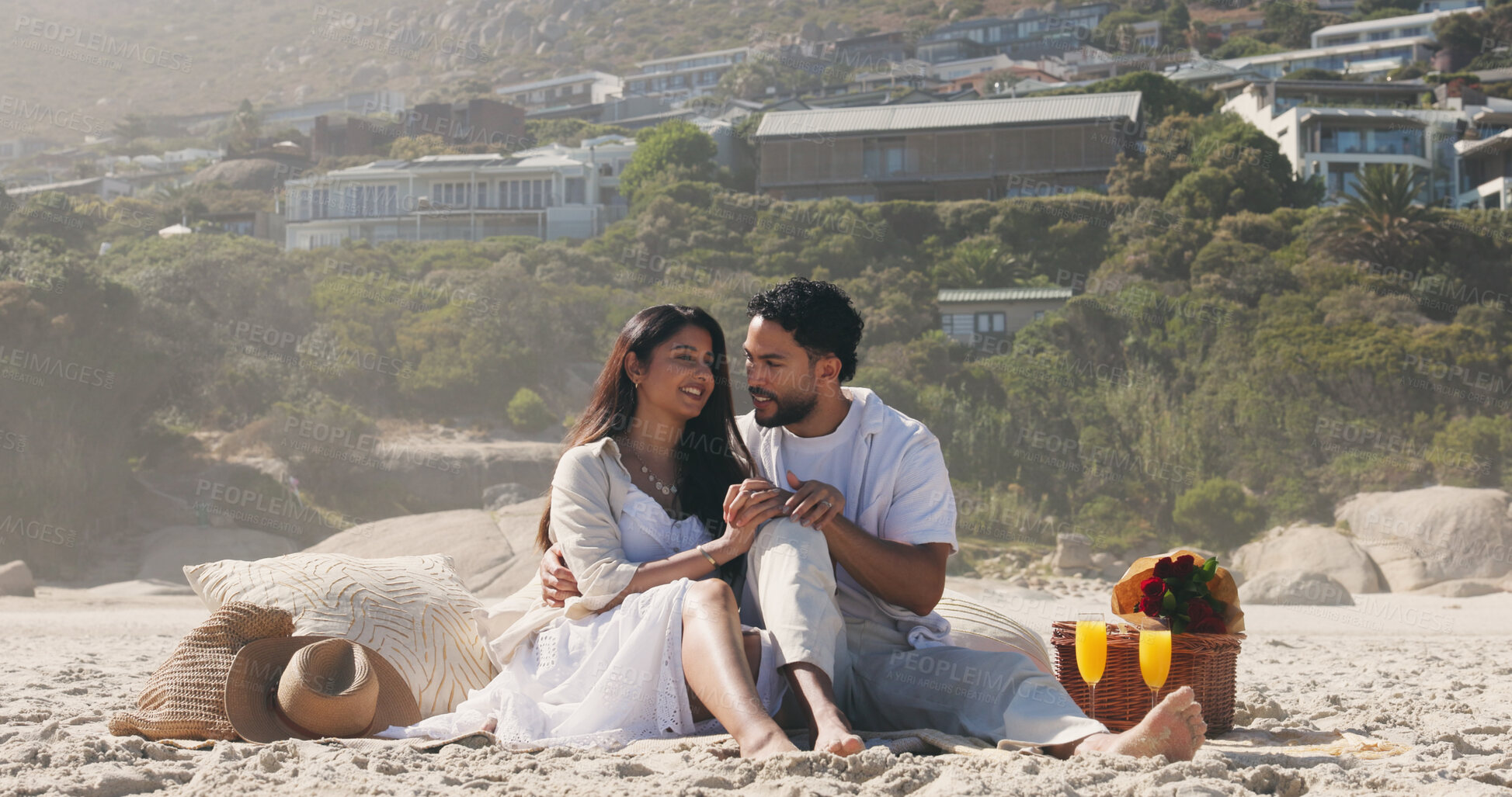 Buy stock photo Couple, holding hands and picnic with love at beach for romantic date, celebration and bonding together. Smile, people and embrace with flowers for romance, anniversary getaway and holiday at seaside