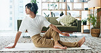 Headphones, stretching and yoga with Asian man in home living room for exercise or wellness routine. Fitness, health and music with yogi person on floor in apartment for balance or holistic activity