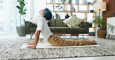 Buy stock photo Music, stretching and yoga with man on floor in home living room for exercise or wellness routine. Fitness, headphones and health with Asian person in cobra pose for balance or holistic activity