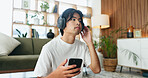 Man, phone and relax with headphones on floor in home with sound, scroll and listen to music in lounge. Person, smartphone and audio with streaming service, subscription and mobile app at apartment