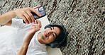 Yoga mat, music and Asian man with smartphone in home for sound, pilates playlist and top view. Mobile, headphones and happy person on floor for fitness podcast, wellness audio and streaming service