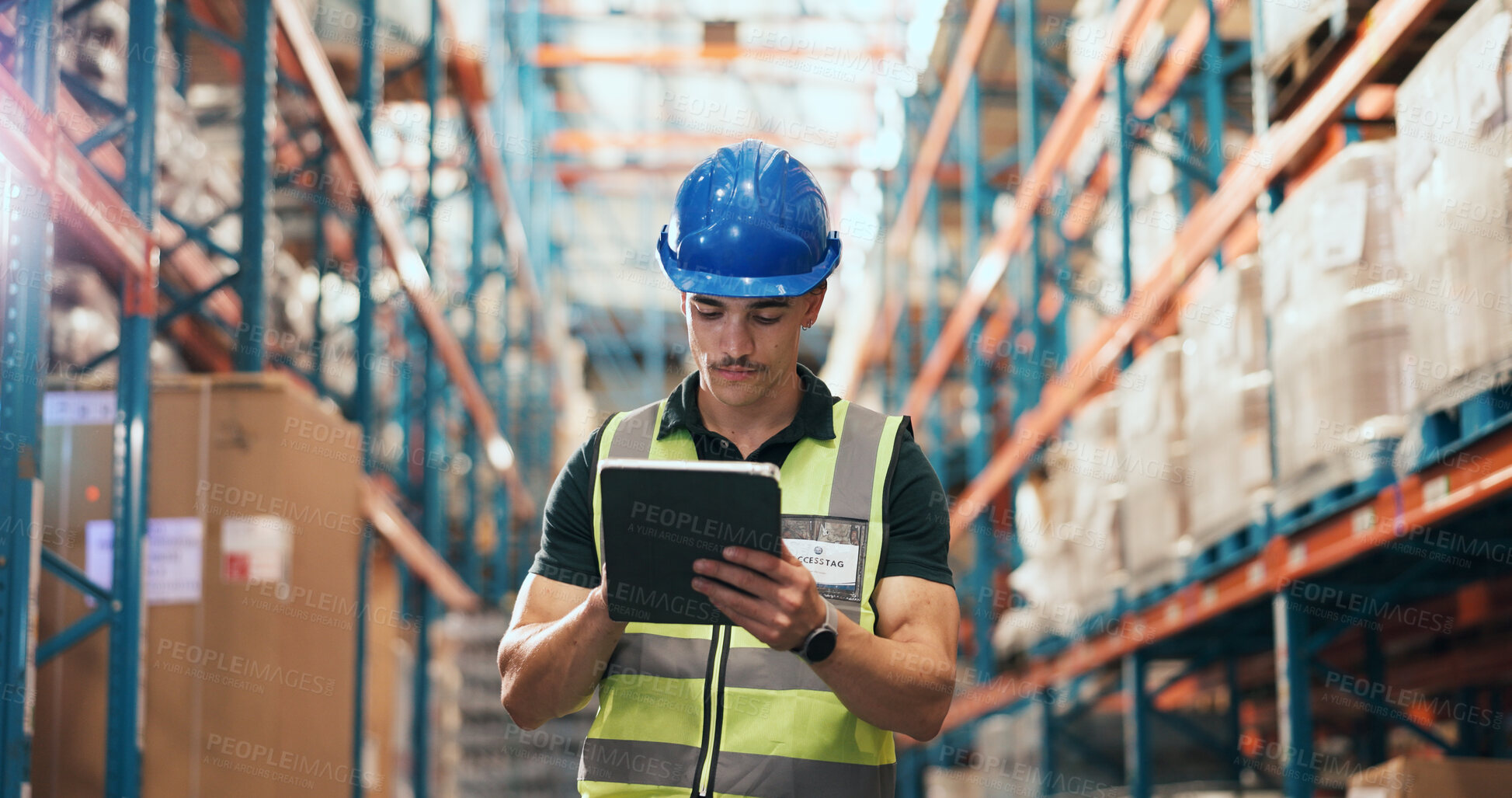 Buy stock photo Man, tablet and typing at warehouse for logistics with notes, schedule or inventory management at shelf. Person, tech and helmet for supply chain, checklist and scroll on application at storage plant
