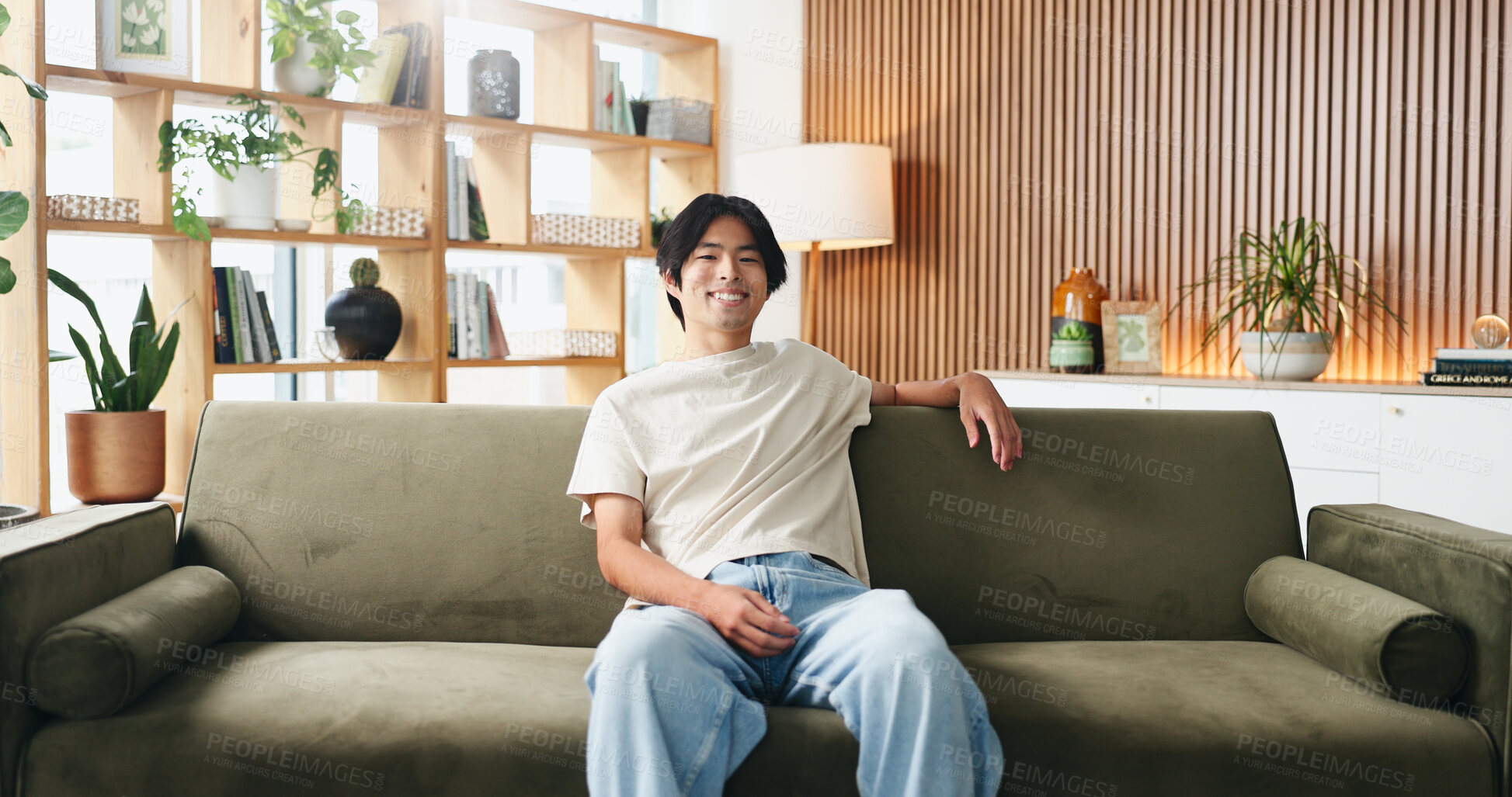 Buy stock photo Portrait, relax and smile of Asian man on sofa in home living room for weekend break as student. Comfortable, confidence and me time with college or university pupil on apartment couch in Japan