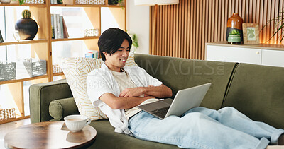 Buy stock photo Education, laptop and smile of Asian man on sofa in home living room for distance learning. Computer, online study and streaming with happy university student in apartment for development or growth
