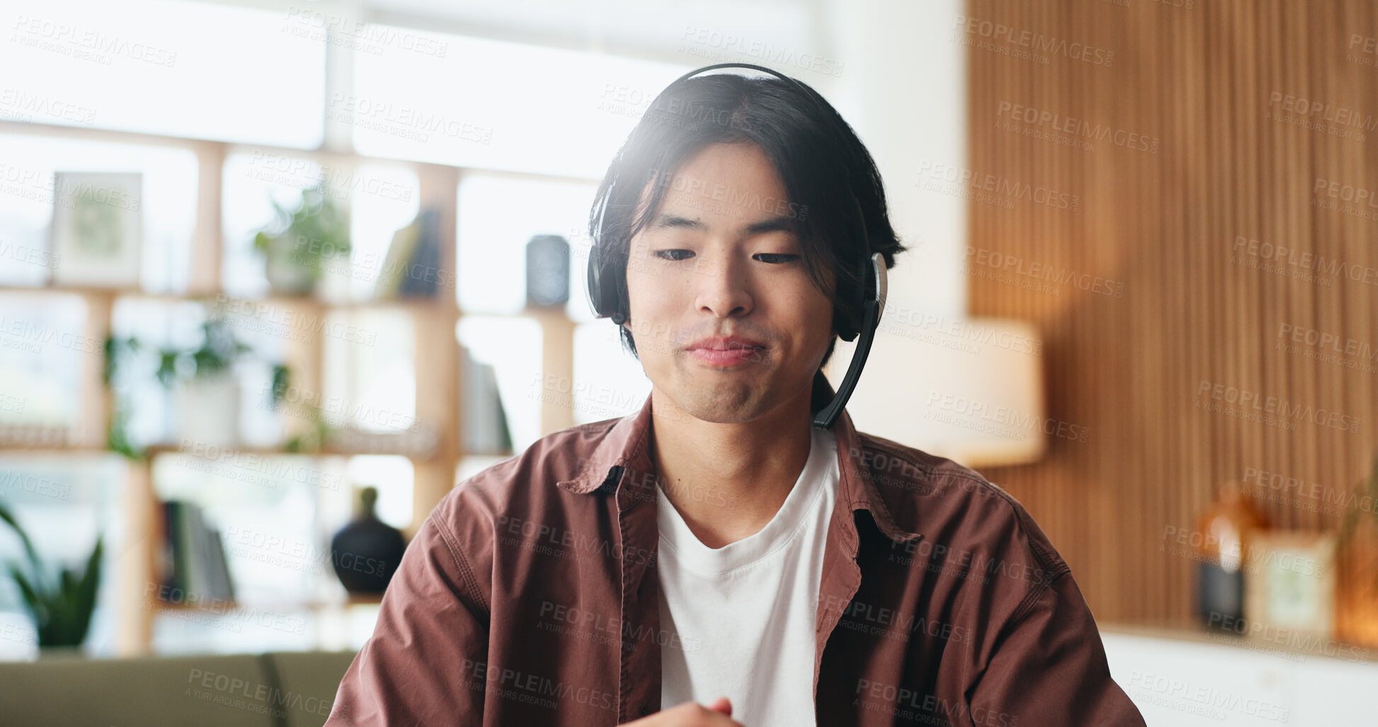 Buy stock photo Man, consultant or remote work with headset in home for customer service, CRM or online advice. Male person, asian agent or freelancer with mic for virtual assistance, help or web support in house