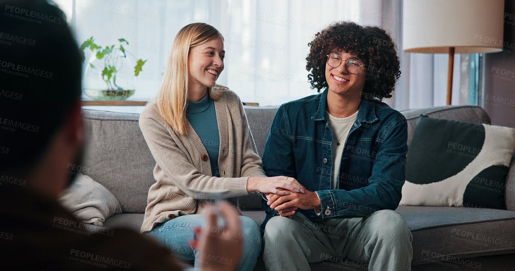 Buy stock photo Psychologist, happy couple and holding hands in consultation for love, support or reconciliation. Man, woman and counseling with therapist for advice, save marriage or help in office with solution