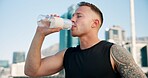 Man, fitness and drinking with water in city for hydration, sustainability or thirst. Active, male person or runner with mineral liquid, beverage or refreshment for rest or recovery in an urban town