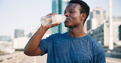 Buy stock photo Black man, fitness and drinking with water in city for hydration, sustainability or thirst. Active, male person or runner with mineral liquid or beverage for break, rest or recovery in an urban town