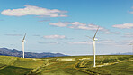 Blue sky, eco friendly and wind turbine outdoor by grass for renewable energy, sustainable or nature. Field, clouds and windmill for natural resource with economic development in countryside.