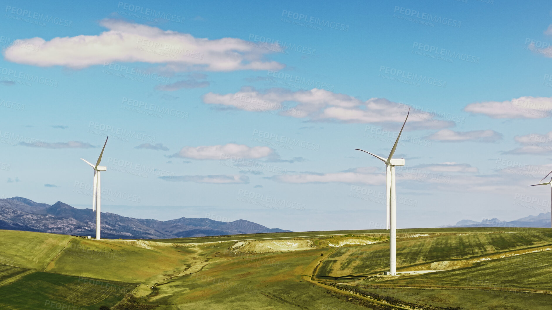 Buy stock photo Blue sky, eco friendly and wind turbine outdoor by grass for renewable energy, sustainable or nature. Field, clouds and windmill for natural resource with economic development in countryside.