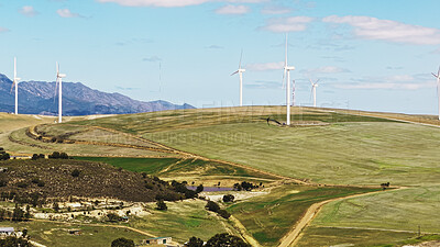 Buy stock photo Blue sky, farm and wind turbine outdoor by grass for renewable energy, sustainable or eco friendly. Nature, clouds and windmill for natural resource with economic development in field in countryside.