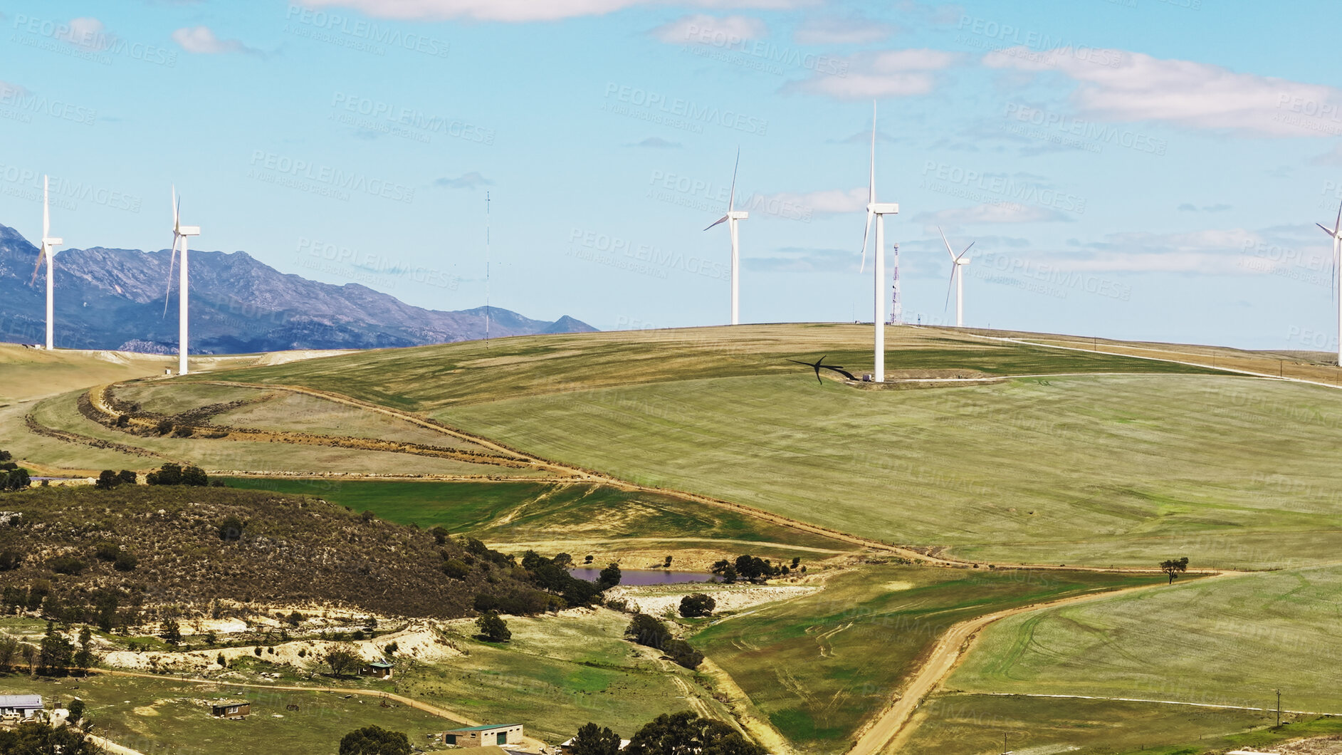 Buy stock photo Blue sky, farm and wind turbine outdoor by grass for renewable energy, sustainable or eco friendly. Nature, clouds and windmill for natural resource with economic development in field in countryside.