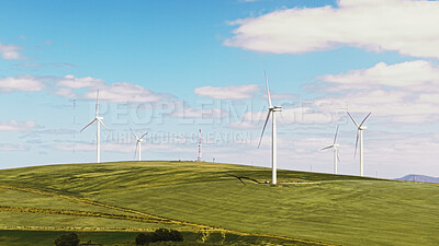 Buy stock photo Blue sky, nature and windmills outdoor by grass for renewable energy, sustainable or eco friendly. Field, clouds and wind turbines for natural resource with economic development in countryside.
