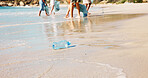 Beach, bottle and recycling litter on sand, trash and volunteer with plastic bag for sustainability. Ocean, pollution and people with social responsibility in nature, outdoor and cleaning garbage