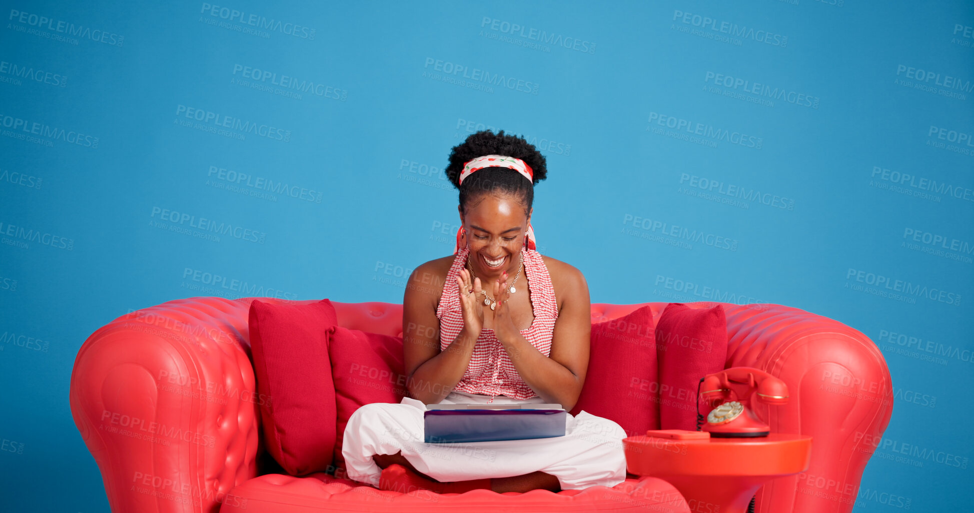Buy stock photo Funny, surprise and tablet with black woman on sofa for reaction to social media post. App, applause and studio with excited African person laughing on blue background for celebration or good news