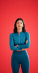 Portrait, athlete and woman with arms crossed in studio, serious and pride for fitness with workout. Red background, wellness and person with confidence on space, strong and body care in Colombia