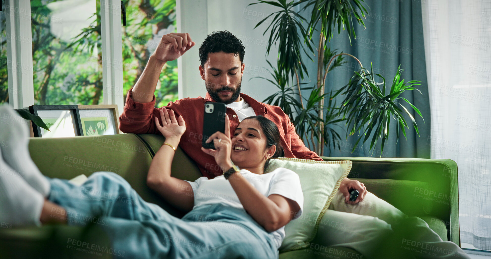 Buy stock photo Happy couple, relax and sofa with phone for social media, network or sharing news in home. Man, woman or lying with smile on living room couch for holiday app, weekend or bonding together in house