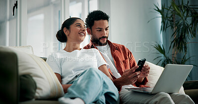 Buy stock photo Happy, talking and couple on sofa with tech for social media, networking and bonding on weekend. Marriage, relax and man with woman on phone and laptop for internet, website and connection in home
