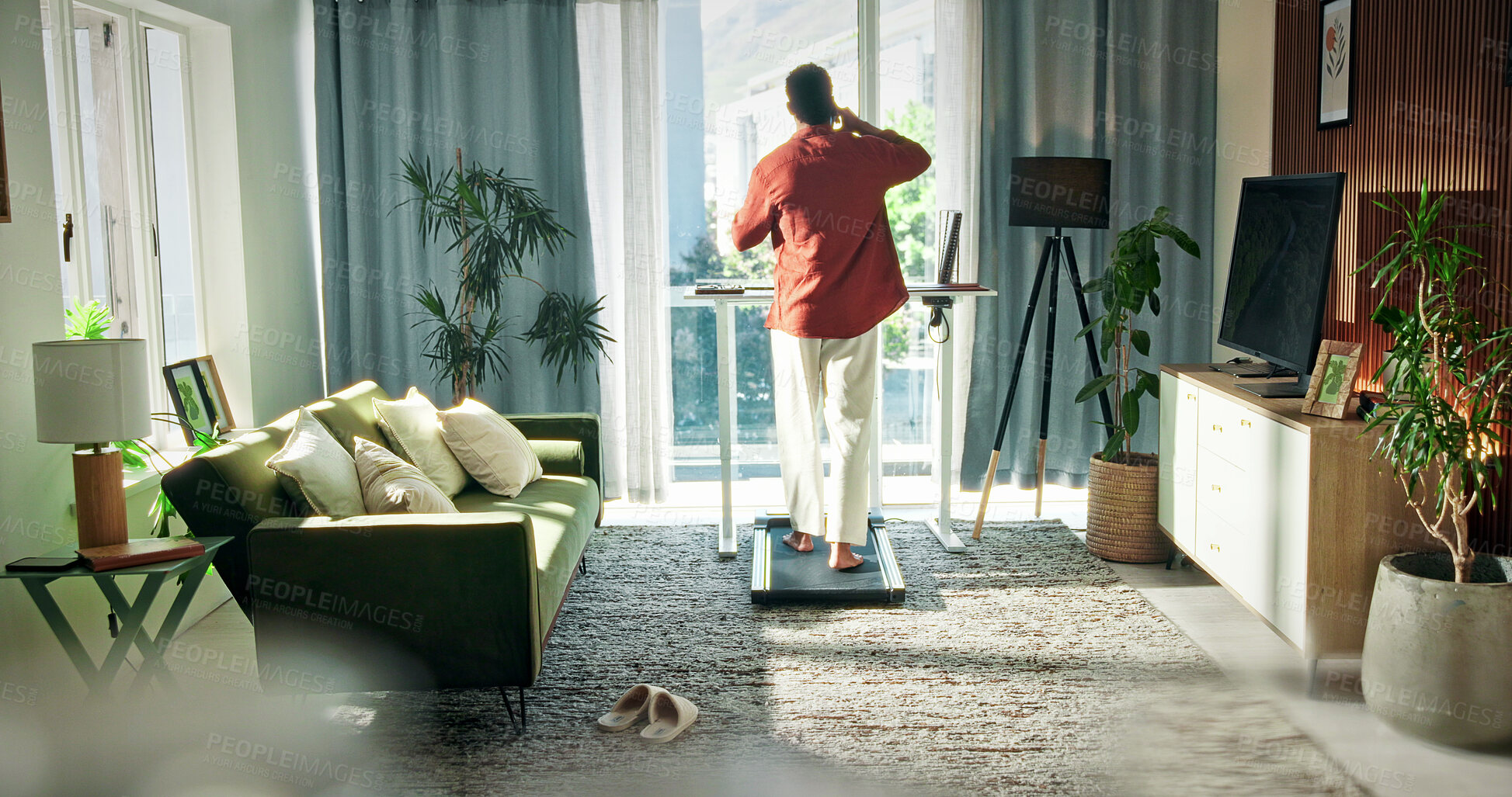 Buy stock photo Freelancer, treadmill and phone call with man in home for communication, multitasking and chat. Remote worker, walking pad and connection with back of person in living room of apartment for contact