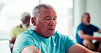 Yoga, class or old man in gym with meditation, calm practice or mindfulness in wellness activity. Holistic, zen or people with inner peace, retirement hobby or mindset improvement in group session.