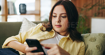 Buy stock photo Woman, relax and reading with phone at house for social media, browsing website and chatting. Female person, scroll and mobile for text message, communication and online notification in living room
