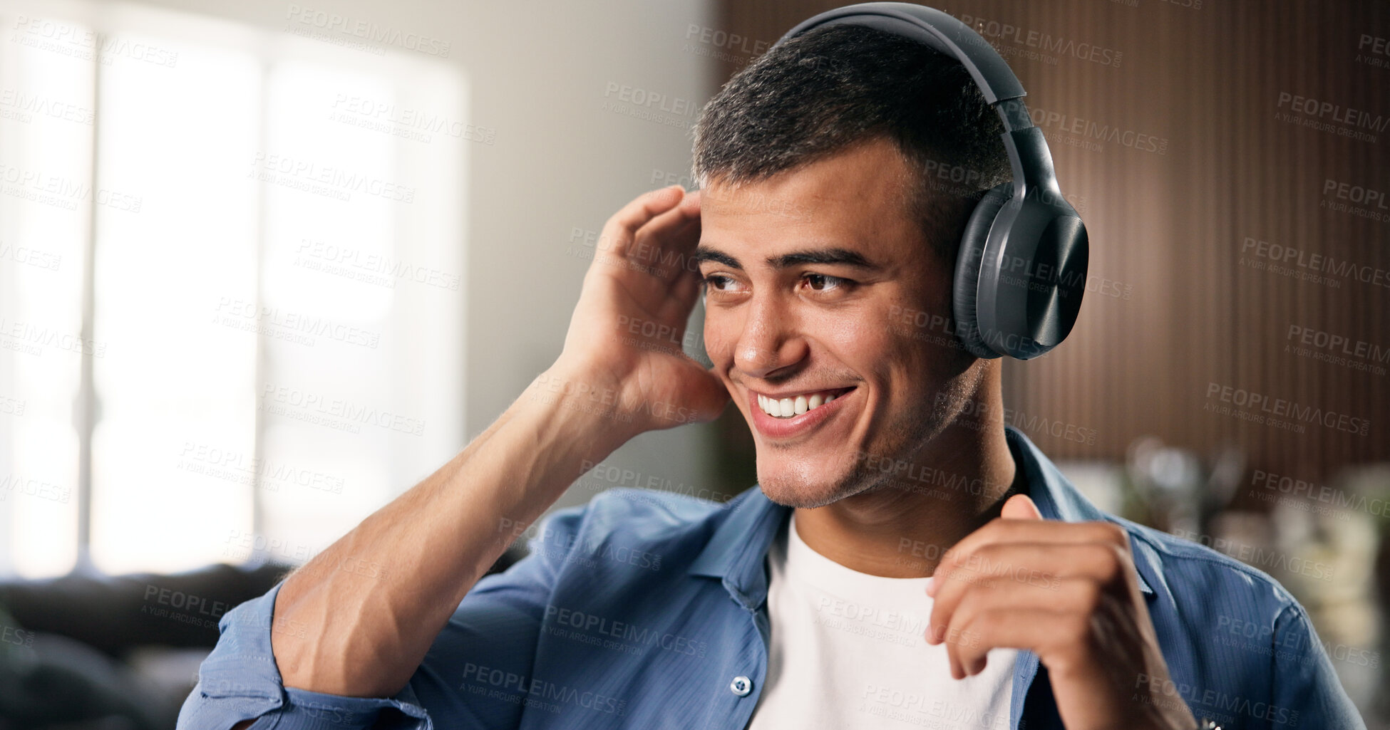 Buy stock photo Headphones, relax and man in home with smile for listening to music, radio or playlist on weekend. Calm, happy and male person streaming album or podcast with audio tech in living room at apartment.