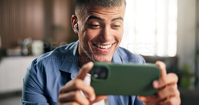 Buy stock photo Earphones, laugh and man with phone in home, streaming web series and online comedy show on weekend. Movie subscription, tech and person with smile for funny scene, binge watching and film website