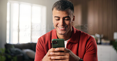 Buy stock photo Man, smile and typing in living room with phone, social media update or text message on dating app. Happy, person relax or scroll in home with browse website, online chat or entertainment on weekend.