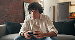 Man, gamer and competition with headset on sofa for challenge, tournament or streaming in home. Male person, player or gaming with mic, controller and online in living room for entertainment in house