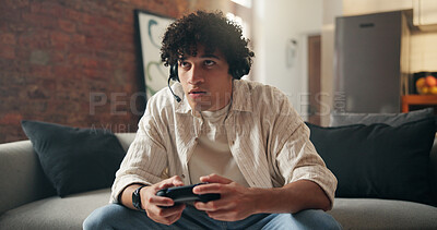Buy stock photo Man, gamer and competition with headset on sofa for challenge, tournament or streaming in home. Male person, player or gaming with mic, controller and online in living room for entertainment in house