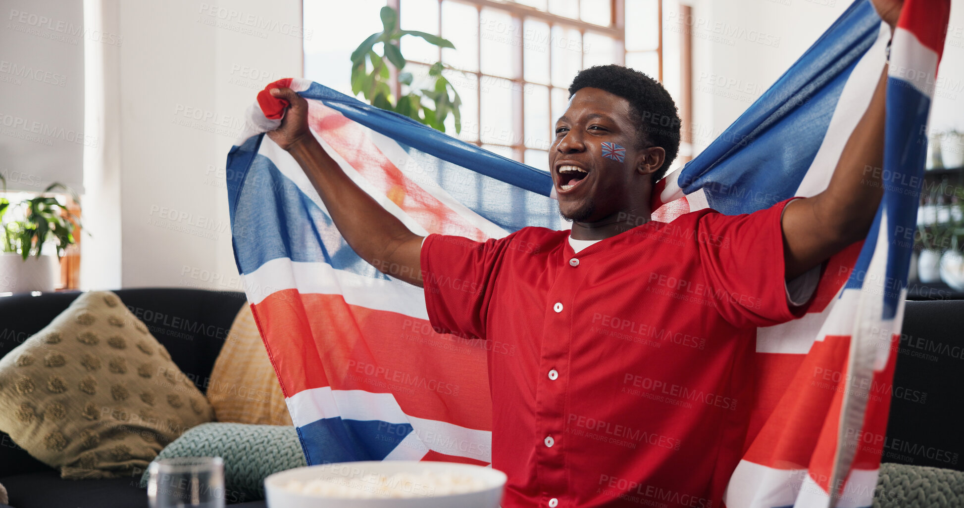 Buy stock photo Black man, UK flag and celebration in home, soccer and cheering for champion, shouting and winning. Fan, screaming and person in lounge, football and excited for score lead, tournament or supporter