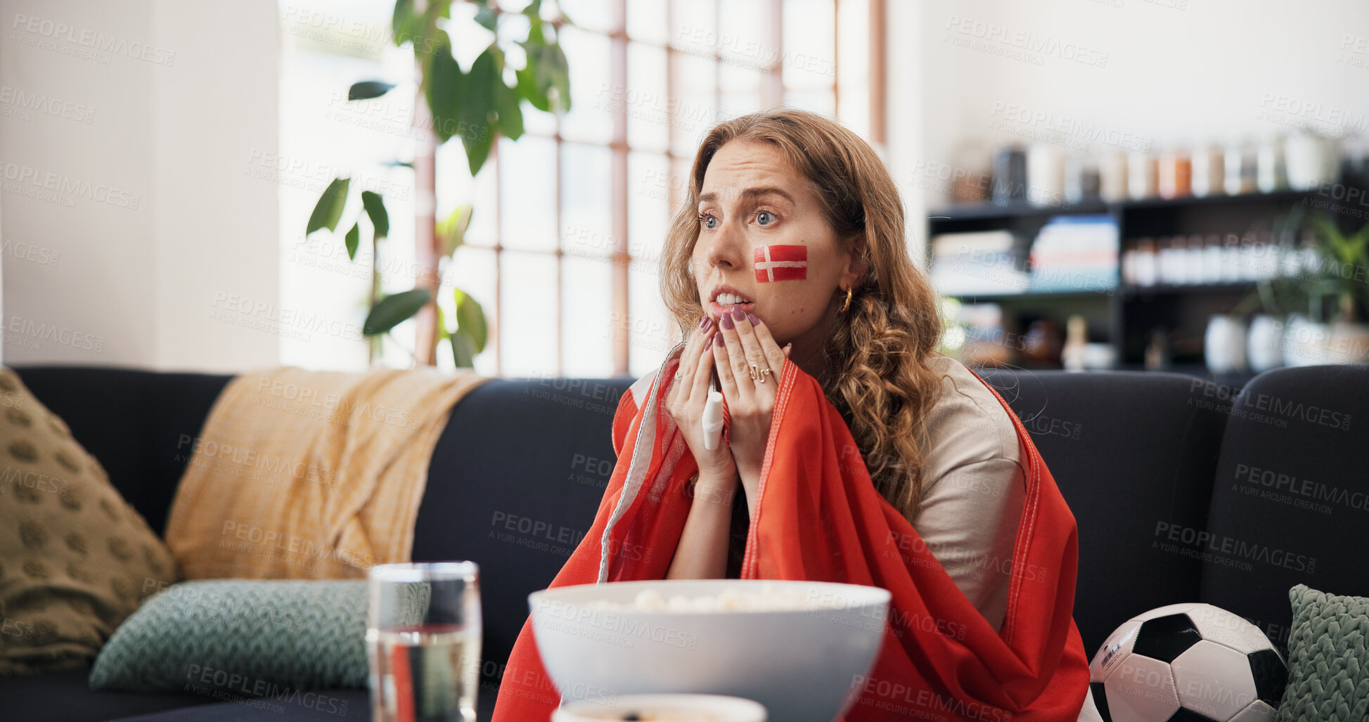Buy stock photo Woman, sports and watching tv in house with Denmark flag, worry or suspense for football competition. Person, stress or nervous in living room with anxiety, tension or broadcast for soccer world cup.