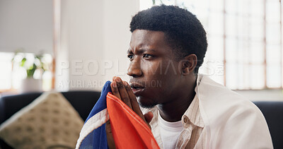 Buy stock photo Man, worry and watching tv in home with sports match, concern and suspense for football competition. Black person, stress and nervous in lounge with anxiety, flag and broadcast for soccer world cup.