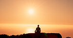 Man, silhouette and meditation with sunset on mountain for spiritual wellness or healing. Calm, male person or lotus pose with sunshine on rock or cliff for zen, inner peace or mental health on space