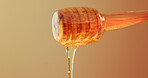 Studio, dripping and honey on wooden dipper, natural antioxidant and organic ingredient for sweetener. Space, sticky liquid and utensil with raw sugar for immunity, healthy food and brown background