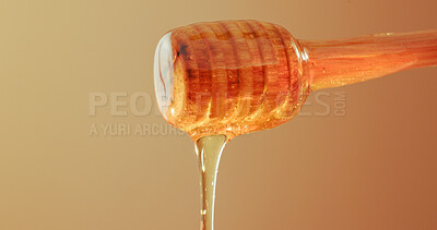 Buy stock photo Studio, dripping and honey on wooden dipper, natural antioxidant and organic ingredient for sweetener. Space, sticky liquid and utensil with raw sugar for immunity, healthy food and brown background
