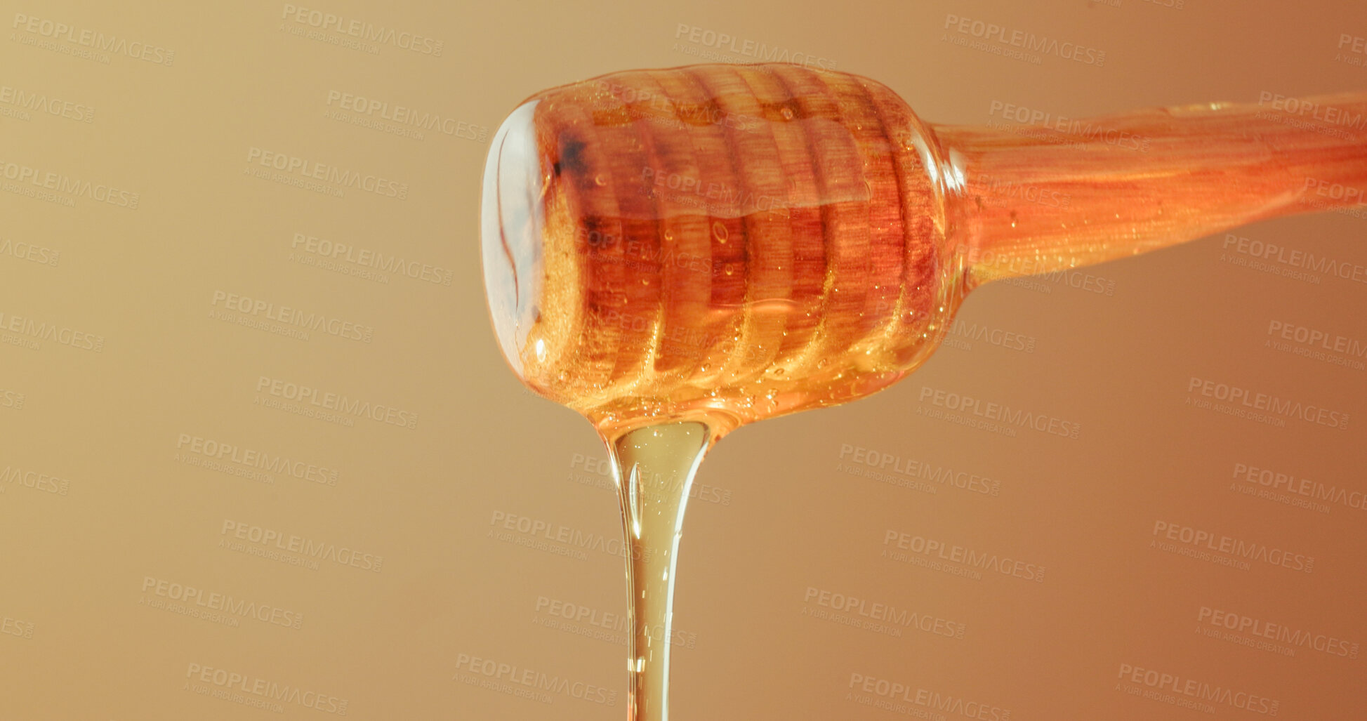 Buy stock photo Studio, dripping and honey on wooden dipper, natural antioxidant and organic ingredient for sweetener. Space, sticky liquid and utensil with raw sugar for immunity, healthy food and brown background