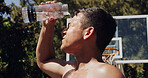 Man, basketball and hydration with water bottle to beat the heat for rest or sport break on court. Active, male person or player with mineral liquid or splash for coolness, refreshment or recovery