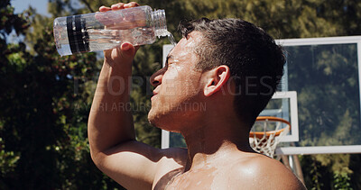 Buy stock photo Teen, basketball and hydration with water bottle to beat the heat for rest or sport break on court. Active, male person or player with mineral liquid or splash for coolness, refreshment or recovery