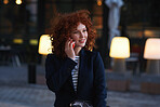 Beautiful red head business woman using smartphone talking on mobile phone in city at sunset