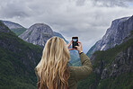 Adventure woman taking photo smart phone of glacial valley landscape on travel exploration for social media