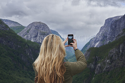 Buy stock photo Woman, travel or mountain with phone for picture of nature, outdoor memory or photography. Back view, female person or tourist hiking with smartphone or app for capture moment of natural scenery
