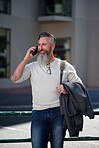 stylish mature man using smartphone having phone call in city street