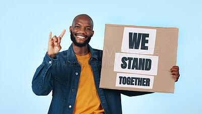 Buy stock photo Hands, poster and portrait of black man in studio for protest, human rights and we stand together. Happy, sign and person with billboard for support, campaign and rally for unity on blue background